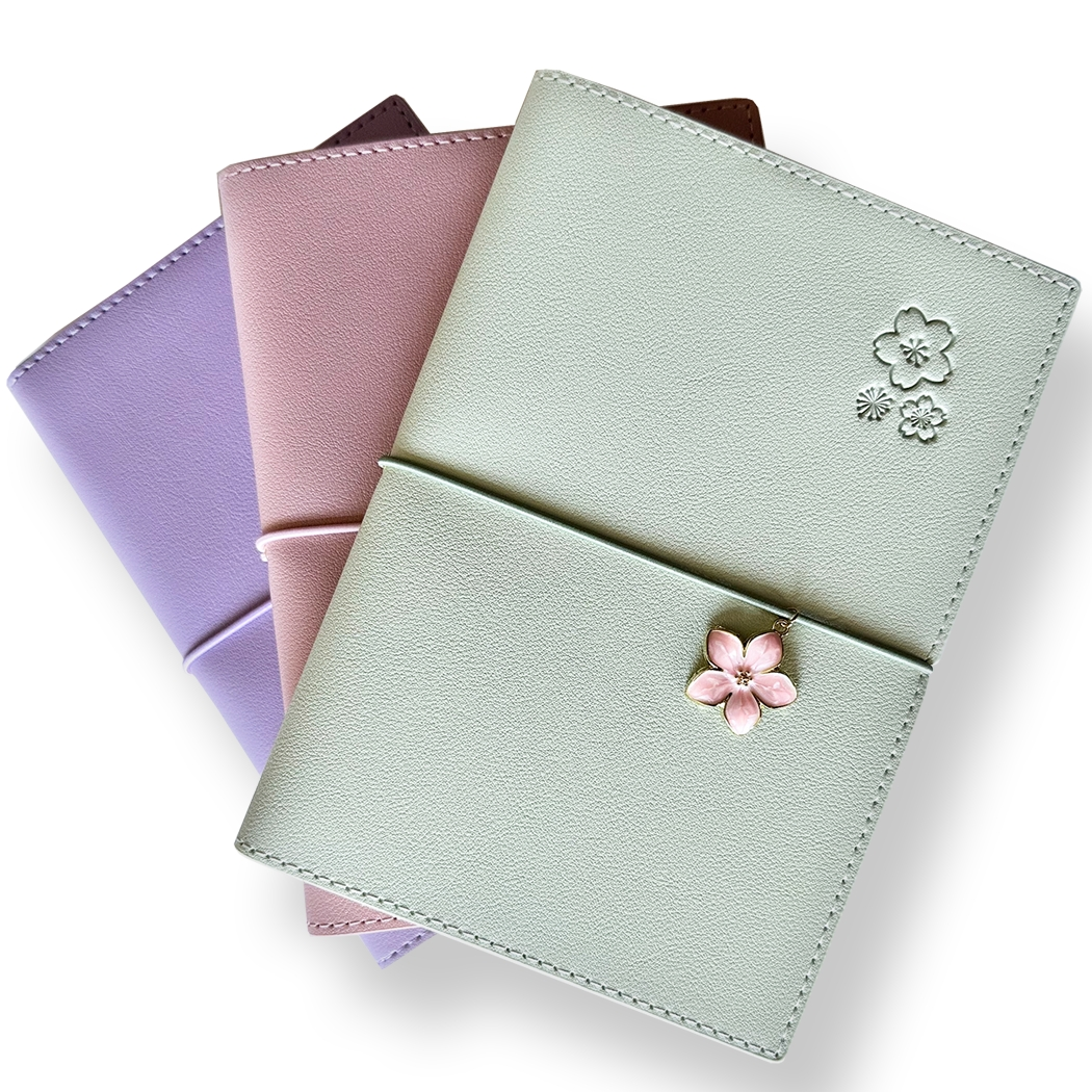 SAKURA journal for girls in stylish fashion colors, high-quality paper, compact and easy to carry, with elastic band and brass floral pendant. By Victoria's Journals.