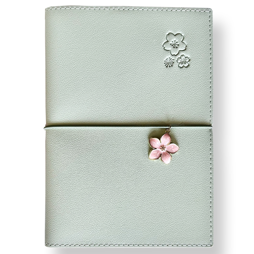 SAKURA journal for girls in stylish fashion colors, high-quality paper, compact and easy to carry, with elastic band and brass floral pendant. By Victoria's Journals.