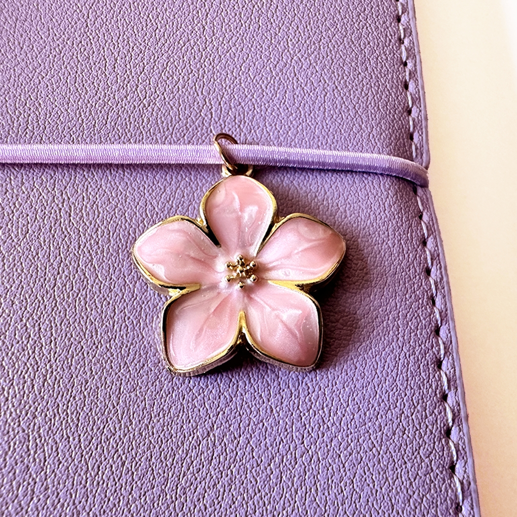 SAKURA journal for girls in stylish fashion colors, high-quality paper, compact and easy to carry, with elastic band and brass floral pendant. By Victoria's Journals. Lialc