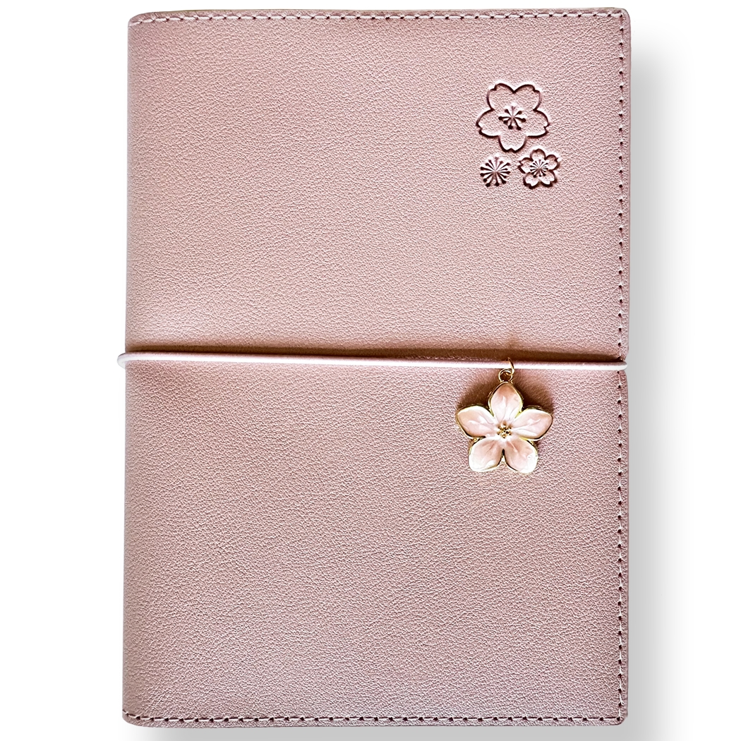 SAKURA journal for girls in stylish fashion colors, high-quality paper, compact and easy to carry, with elastic band and brass floral pendant. By Victoria's Journals. Pink