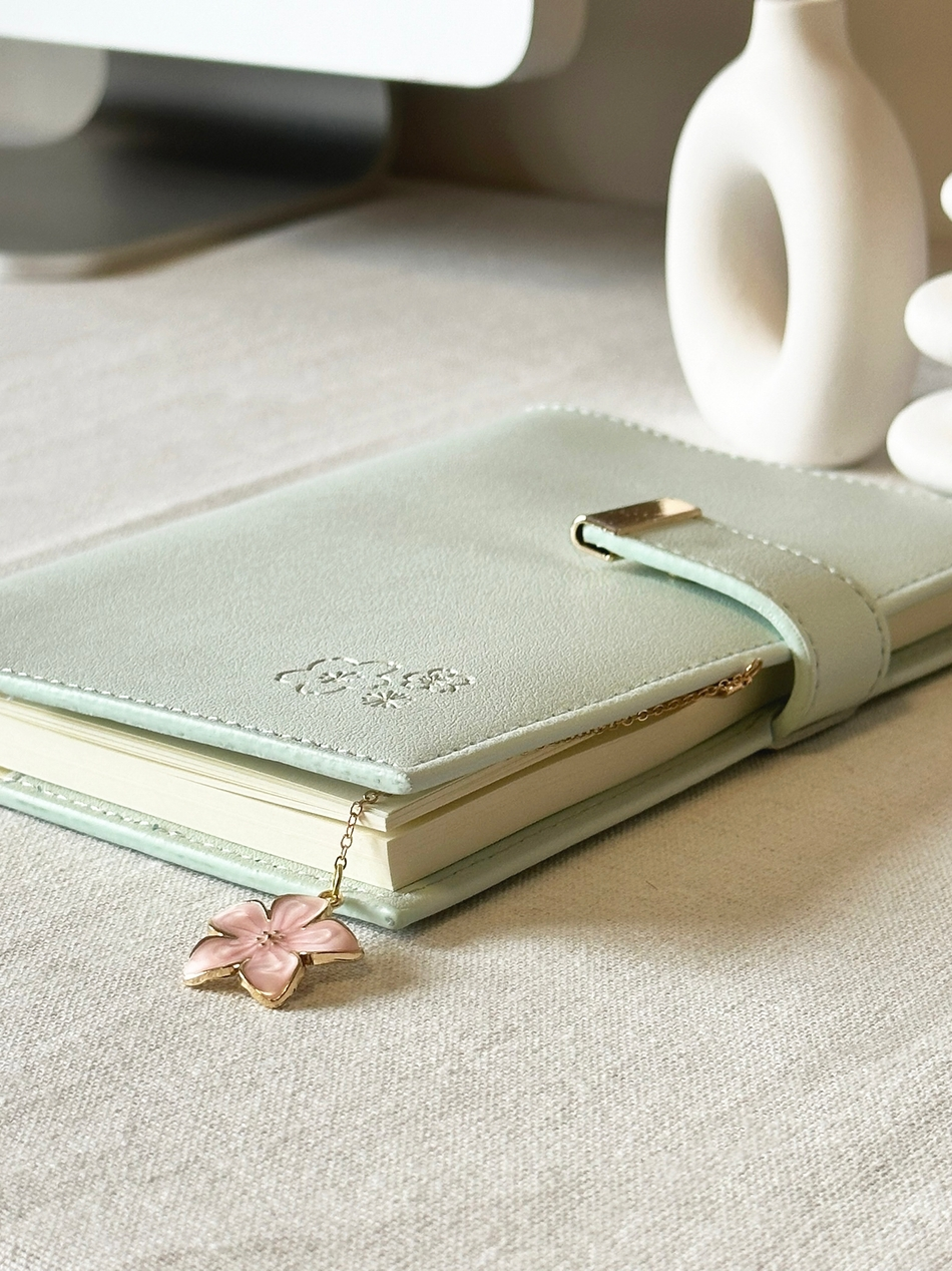 SAKURA journal for girls in trendy fashion colors with high-quality paper, compact design, button flap, brass floral bookmark, and gift box packaging. Victoria's Journals. Pink Green